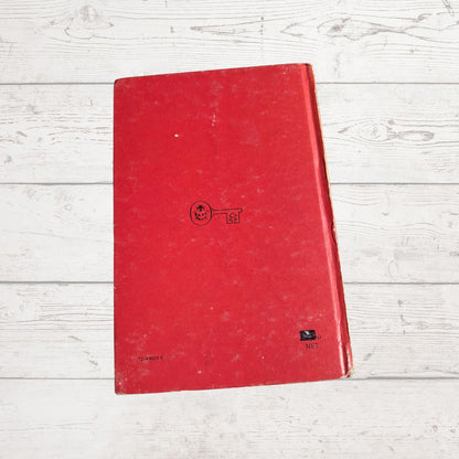 Red book  with a logo on a light wooden surface 