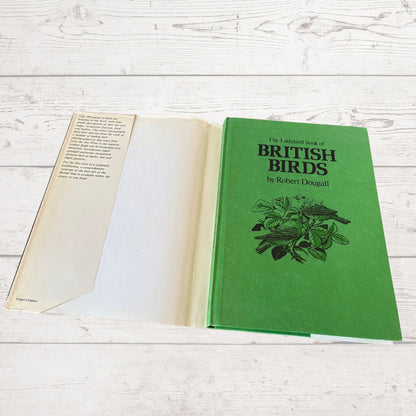 Open book titled 'The Ladybird Book of British Birds' on a wooden surface