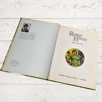 Open book with 'Robin Hood' title and cover illustration on a wooden surface