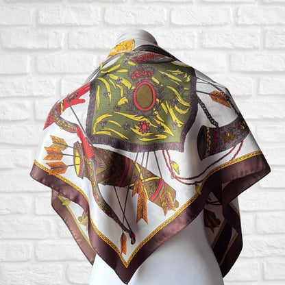 Decorative scarf with intricate patterns draped over a white brick wall background