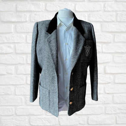 Black and white blazer with black collar and white shirt on a mannequin against a white brick wall.