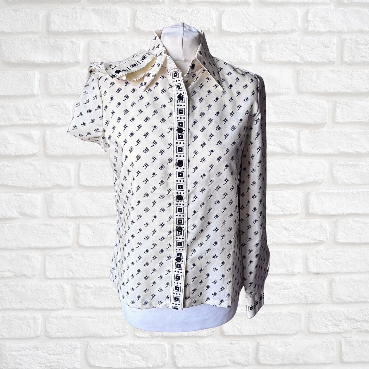 Cream and black geometric print 70s shirt on a white background 