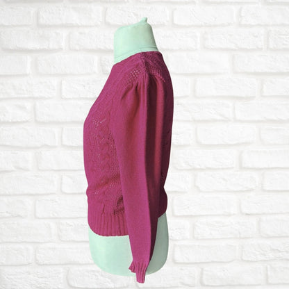 Pink sweater on a mannequin against a white brick wall background