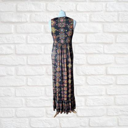 Sleeveless dress with a colorful pattern on a mannequin against a white brick wall.
