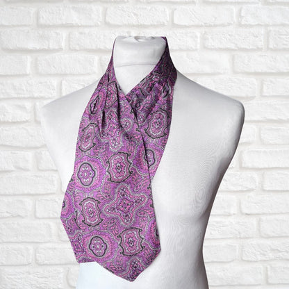 Purple paisley scarf on a mannequin against a white brick wall background