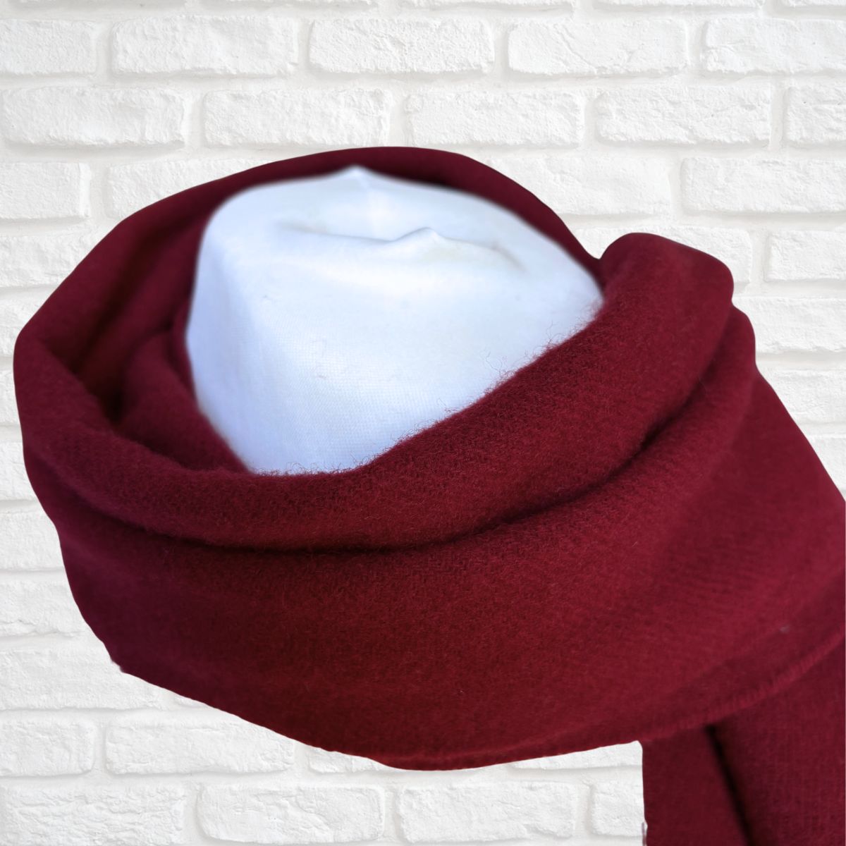 Red scarf with white interior on a textured white background