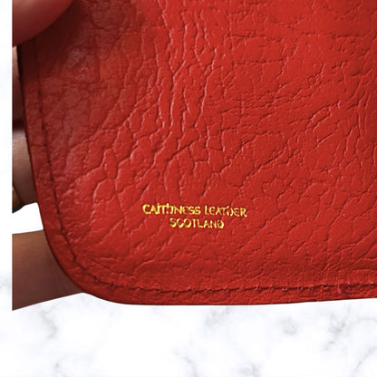 Red leather product with 'Caithness Leather Scotland' branding on a white background