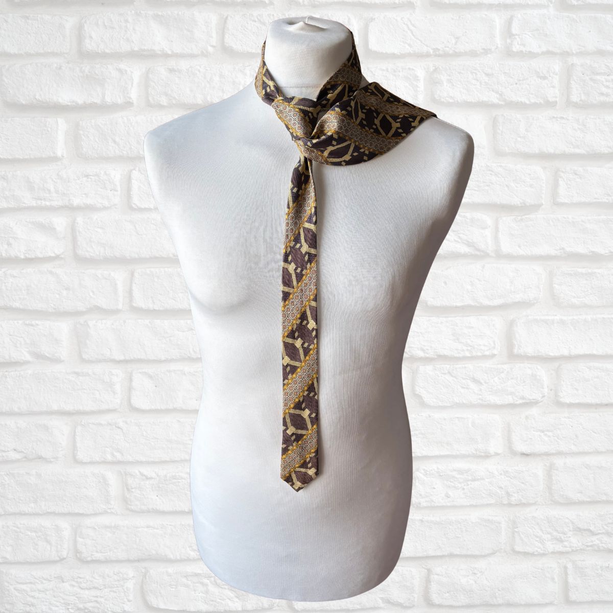 Mannequin wearing a patterned tie against a white brick wall background