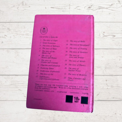 A pink book cover with printed track listings and an 18-net price box, photographed on a whitewashed wood surface.
