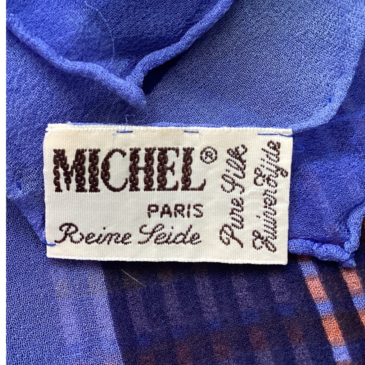 Fabric label with 'MICHEL PARIS' on a blue fabric background