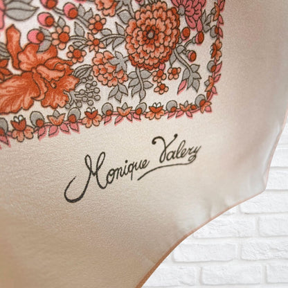 Floral patterned fabric with 'Monique Valery' branding on a white brick background