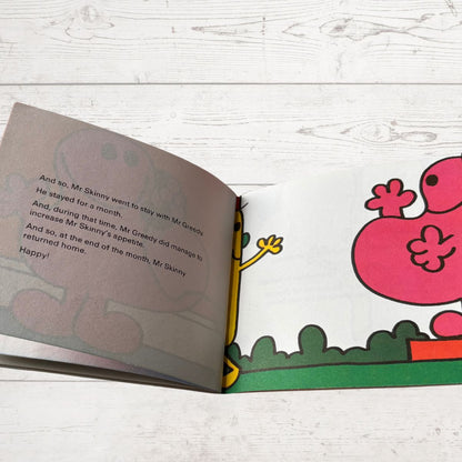 Open book with cartoon characters on a wooden surface