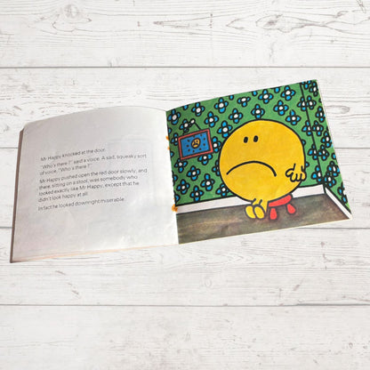Open book with a sad yellow character on a green background