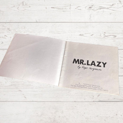 Open book with 'MR. LAZY' title on a light wooden surface