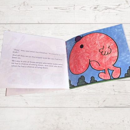 Open book with a red character on a blue background on a wooden surface