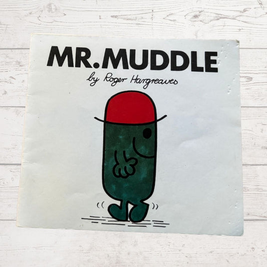 Book cover of 'Mr. Muddle' by Roger Hargreaves on a light wooden surface.