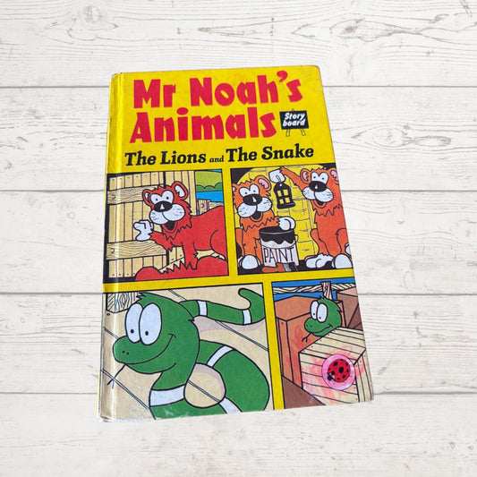 Children's book titled 'Mr Noah's Animals: The Lions and The Snake' on a wooden surface