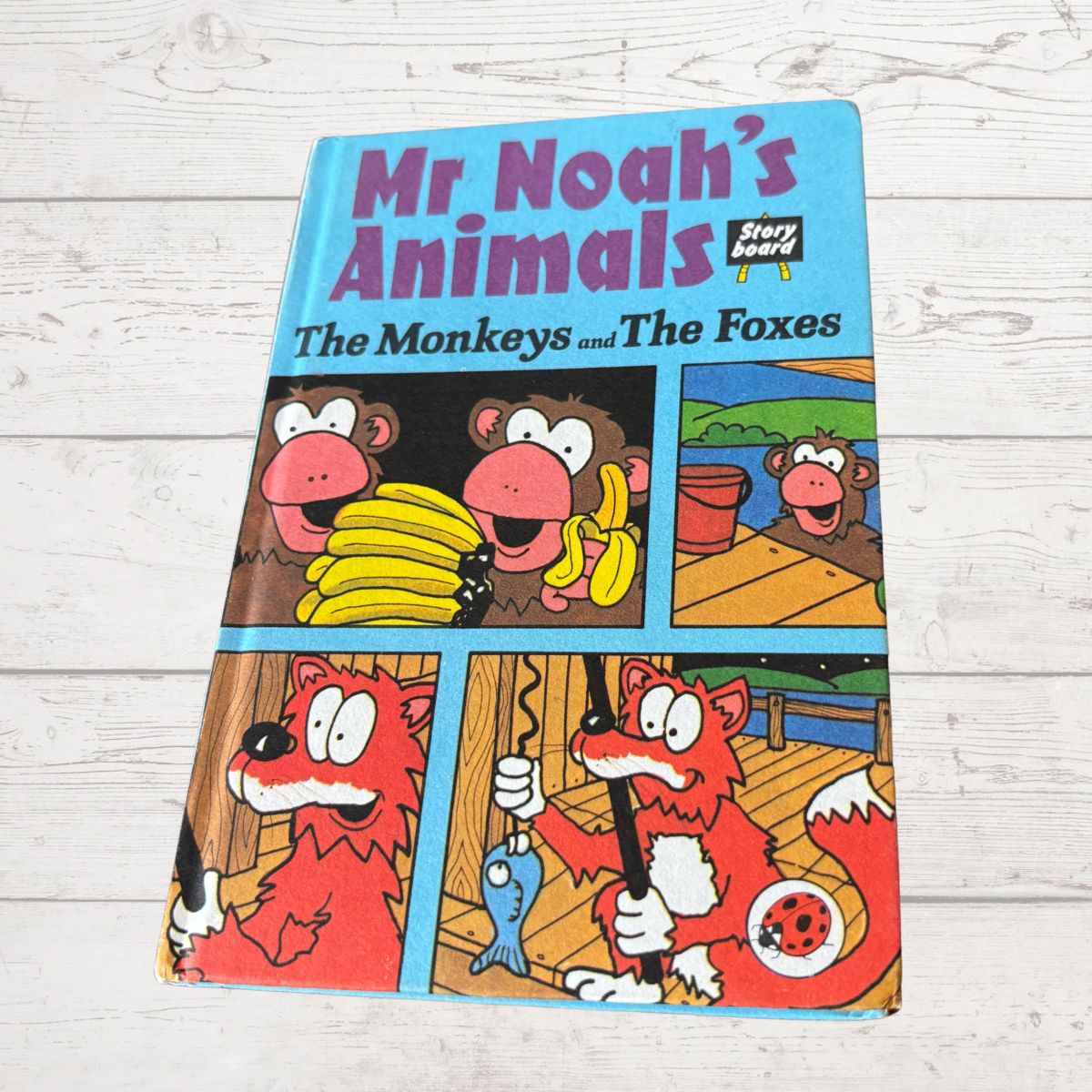 Children's book titled 'Mr Noah's Animals: The Monkeys and The Foxes' on a wooden surface