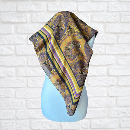 Patterned scarf draped over a mannequin against a white brick wall