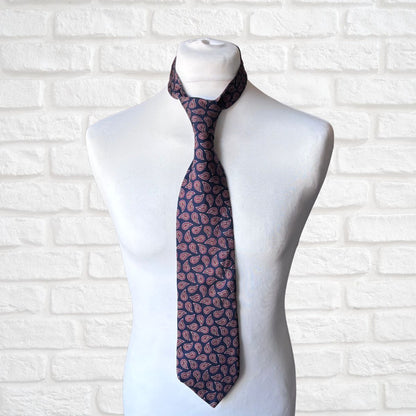 Navy and Red Paisley Silk Vintage Tie On a white brick background 