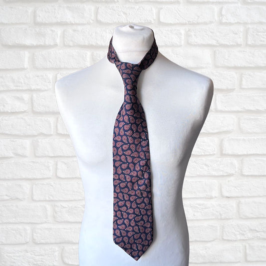 Navy and Red Paisley Silk Vintage Tie On a white brick background 