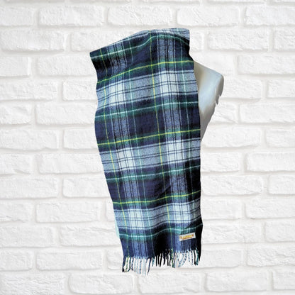 Plaid scarf on a mannequin against a white brick wall background
