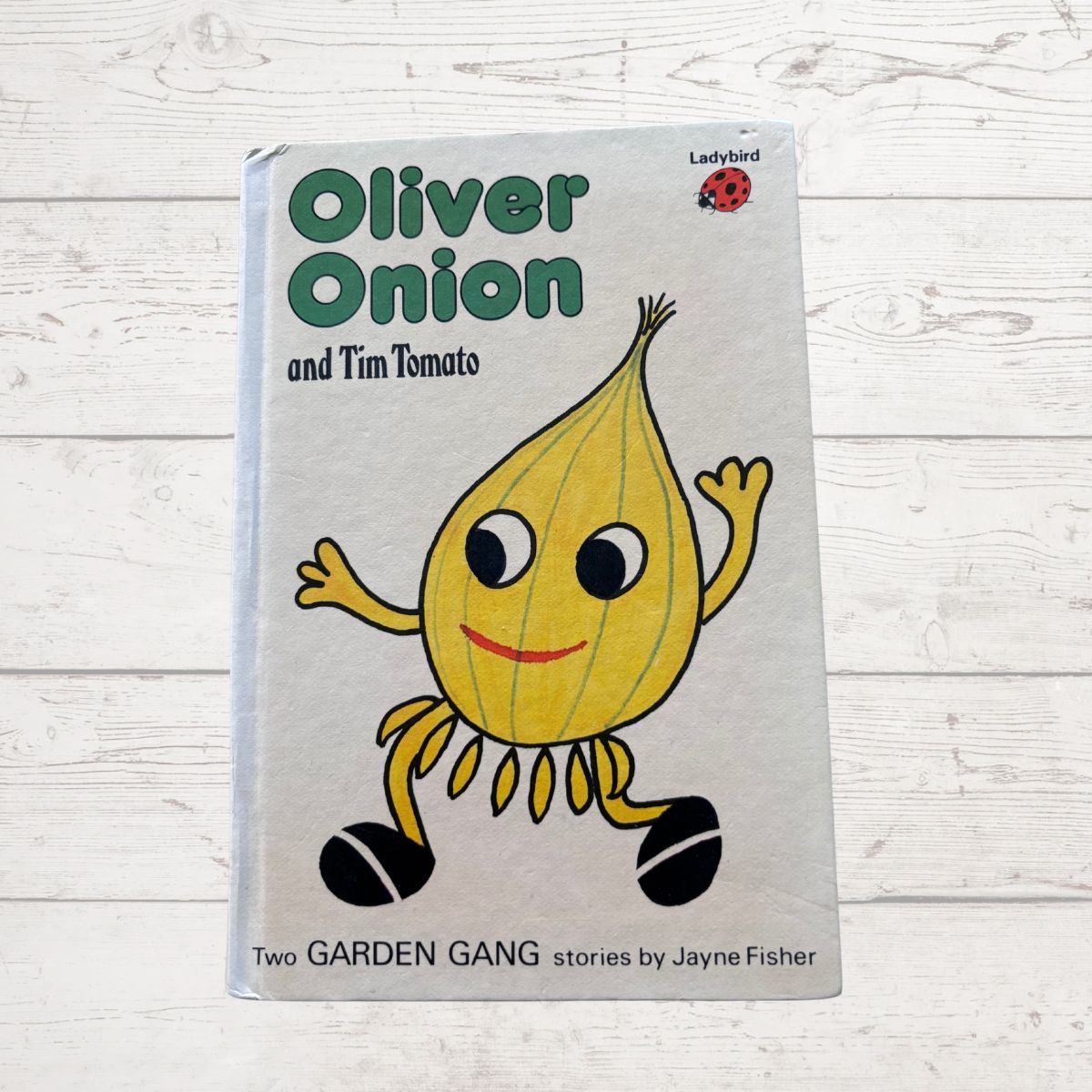 Book titled 'Oliver Onion and Tim Tomato' with a cartoon onion character on a light wooden background