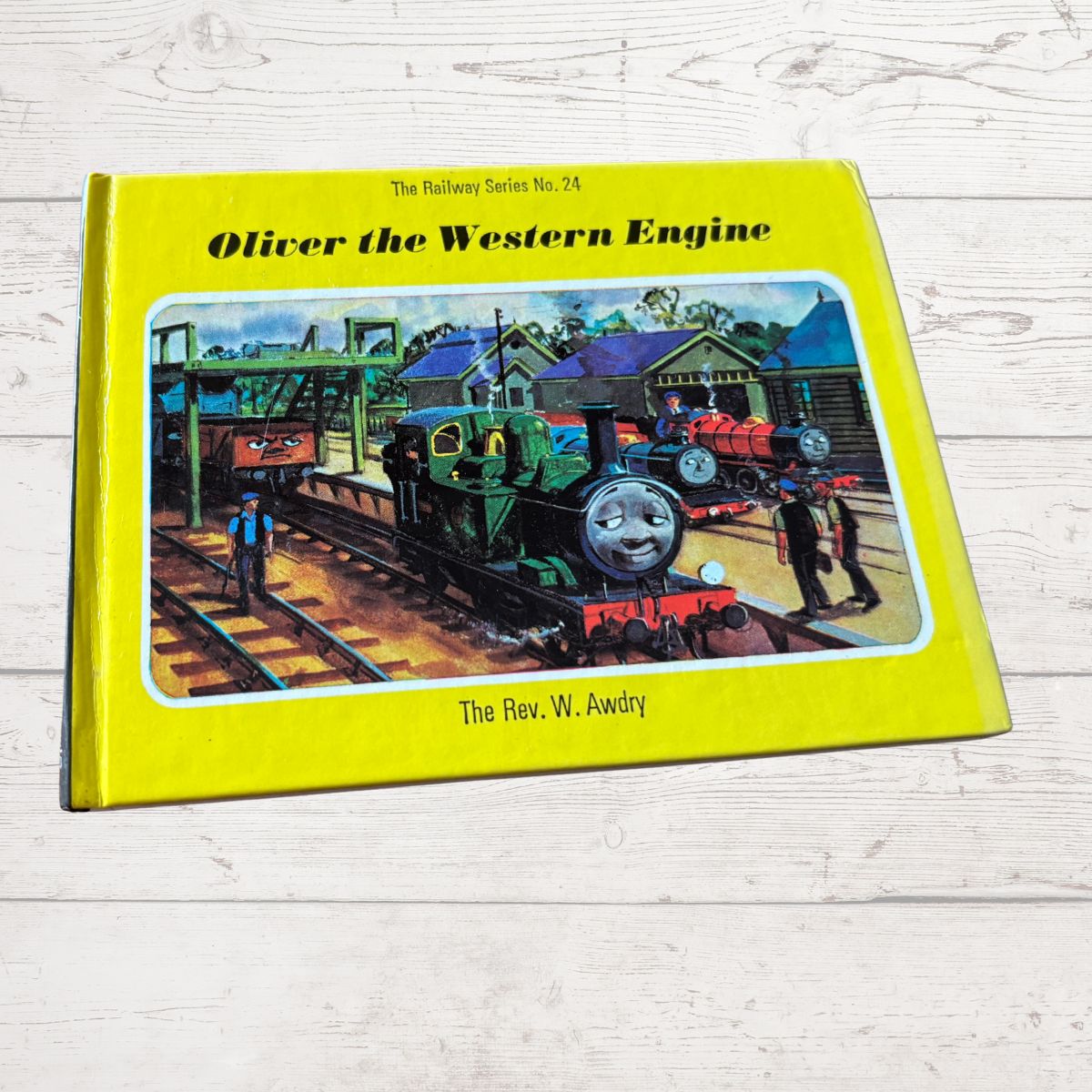 Book titled 'Oliver the Western Engine' on a wooden surface