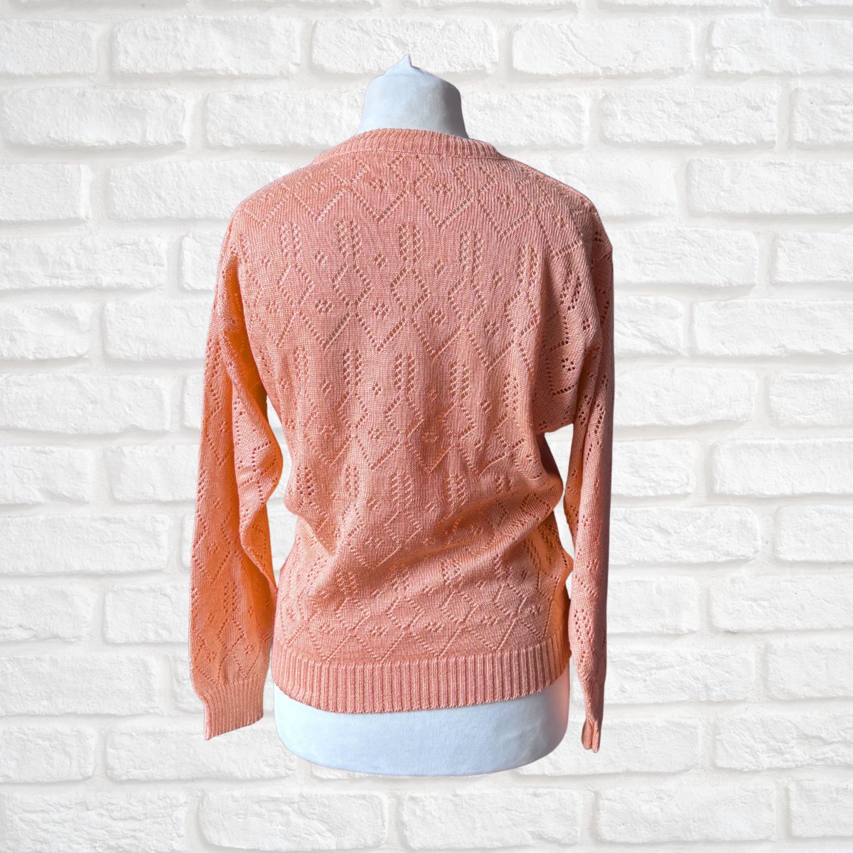 Back view of a peach open knit sweater 