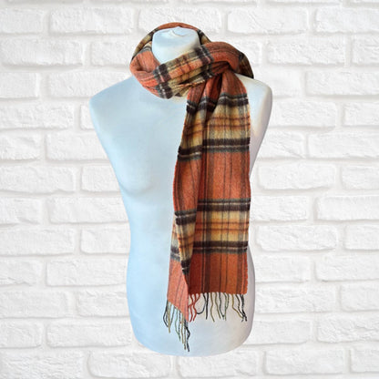 Plaid scarf on a mannequin against a white brick wall background