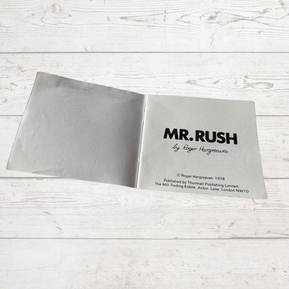 Open book with 'MR. RUSH' title on a white wooden surface