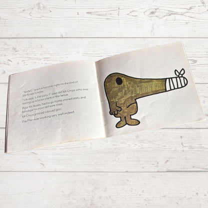 Open book with a cartoon character on a wooden surface