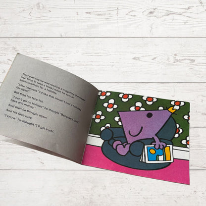 Open book with a colorful illustration of a purple character on a white wooden surface