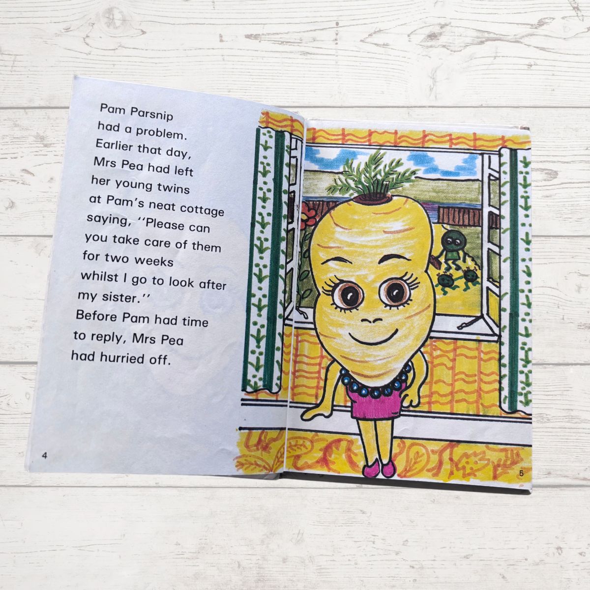 Open book with a cartoon character on a wooden surface