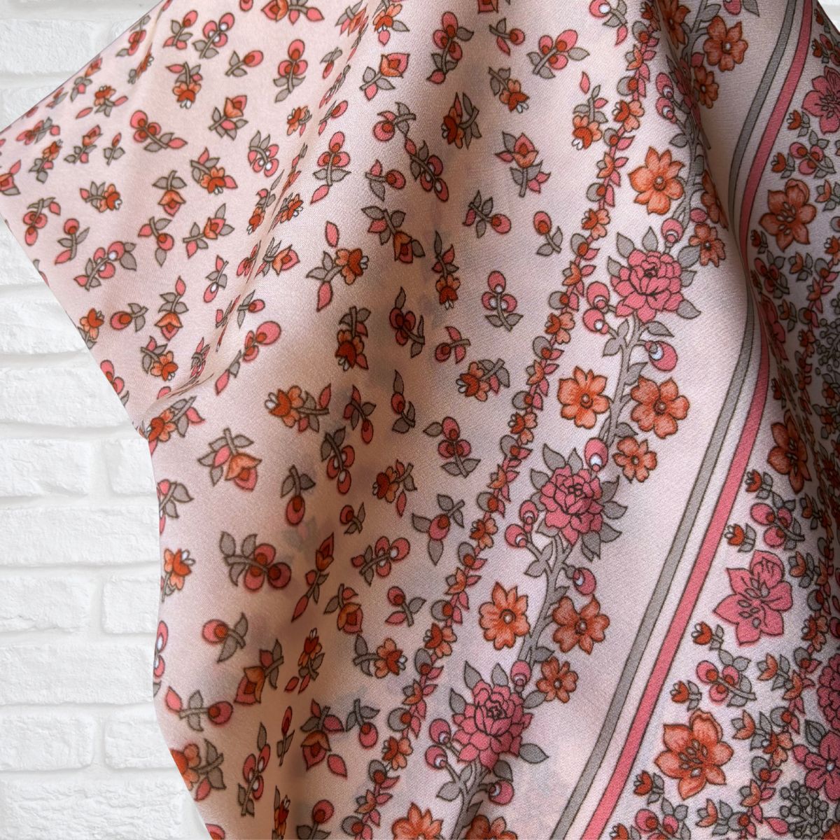 Floral patterned fabric with pink and orange flowers on a white background