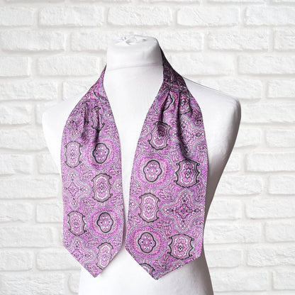 Purple paisley scarf on a mannequin against a white brick wall background
