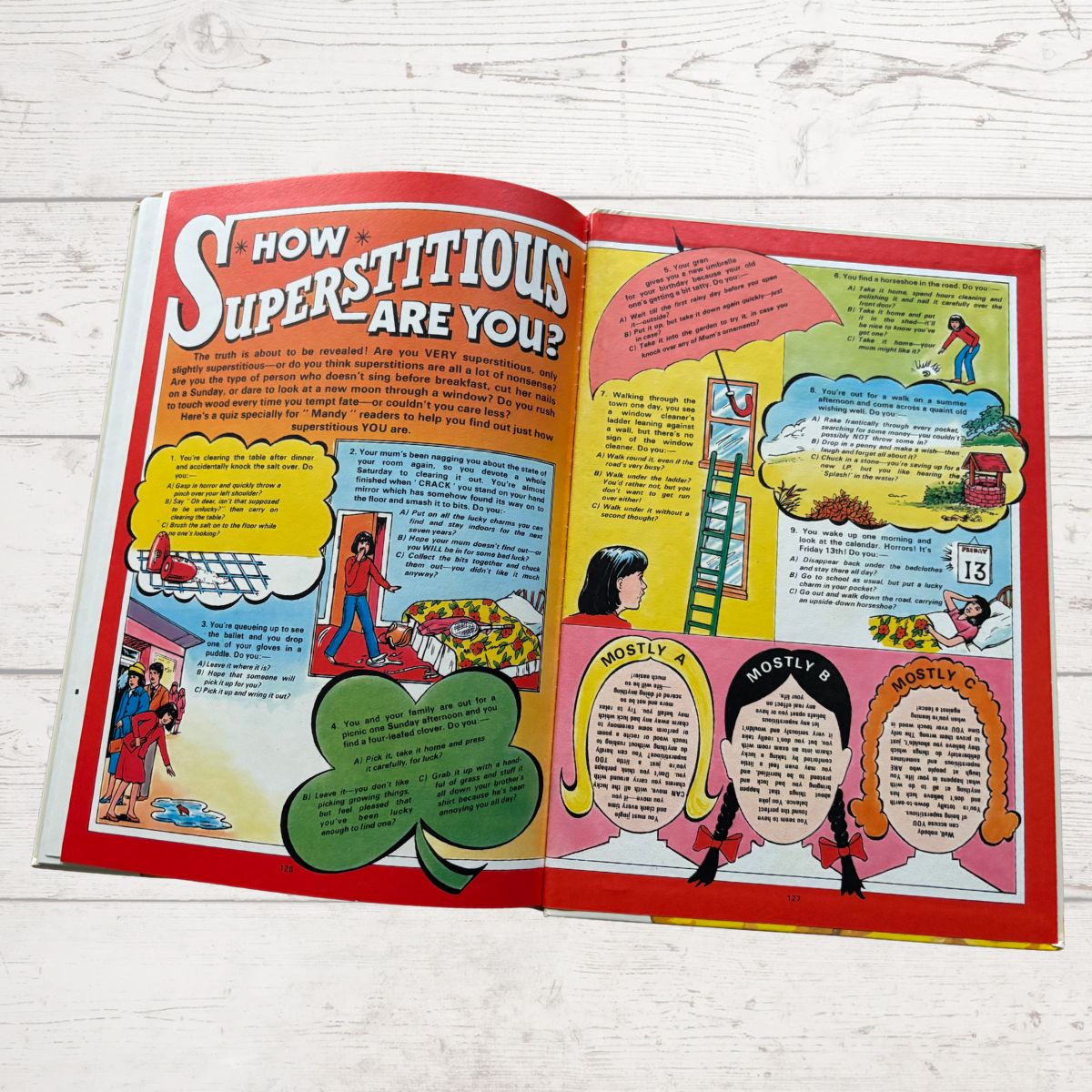 Open book with colorful pages on a white wooden surface