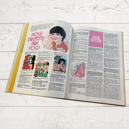Open book with illustrations and text on a wooden surface