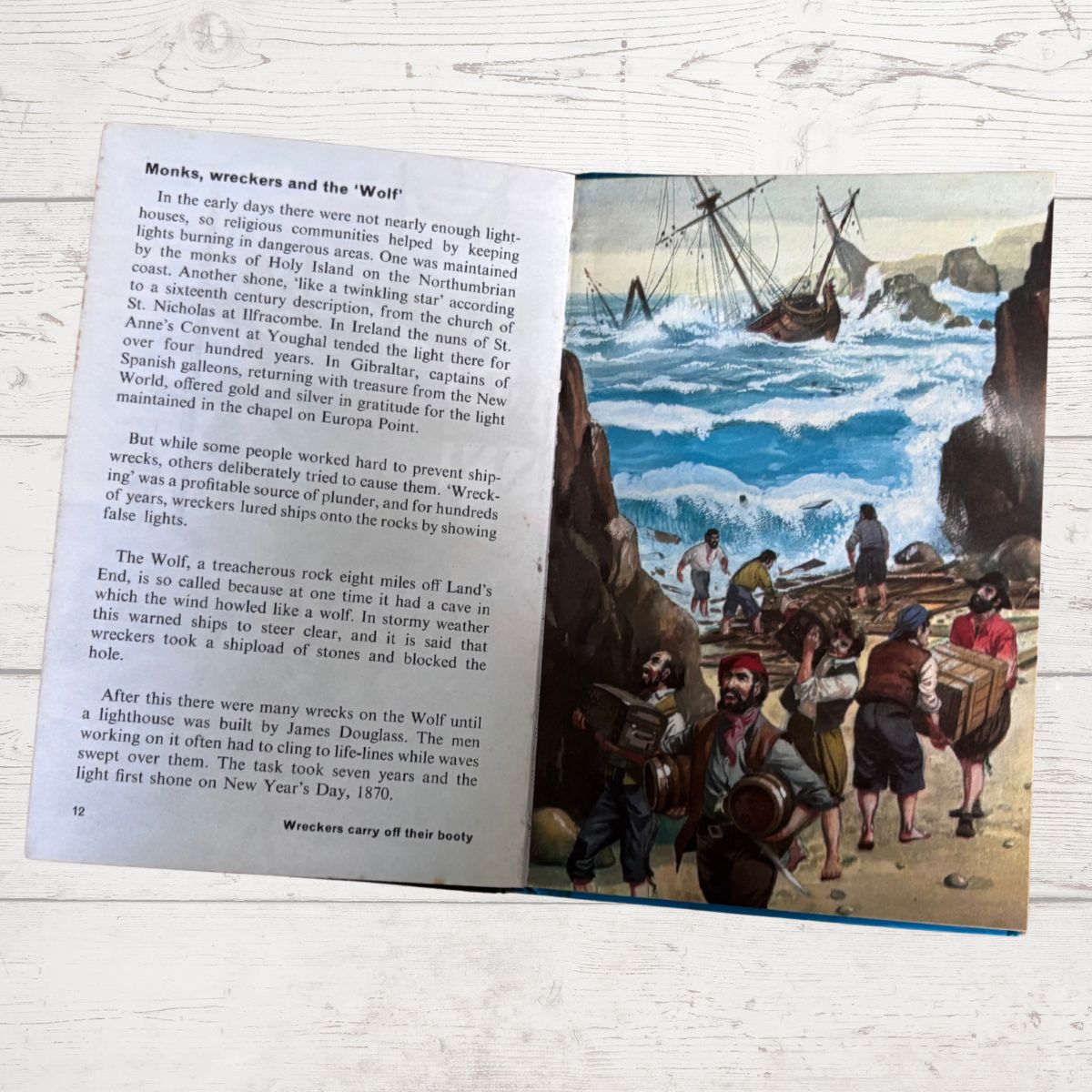 An open book page showing a printed article about whalers with a black-and-white illustration of men handling a whale on deck. The page is photographed against a light wood background.