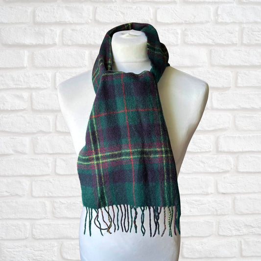 Plaid scarf on a mannequin against a white brick wall background