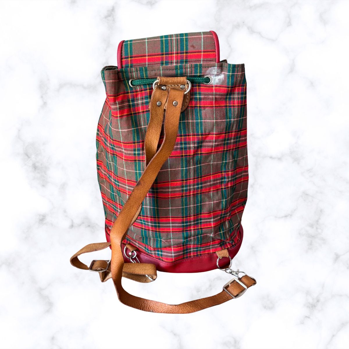 Plaid backpack with brown leather straps on a white background