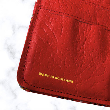 Red leather wallet with 'Made in Scotland' text on a white background