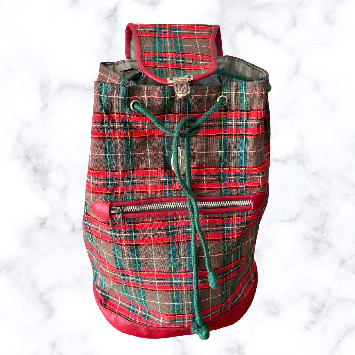 Plaid backpack with red, green, and brown colors on a white background
