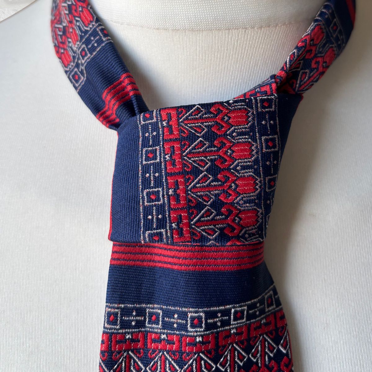 Traditional patterned tie  on a mannequin with a plain background