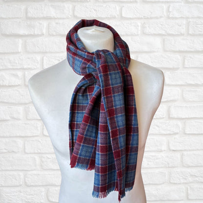 Plaid scarf on a mannequin against a white brick wall background