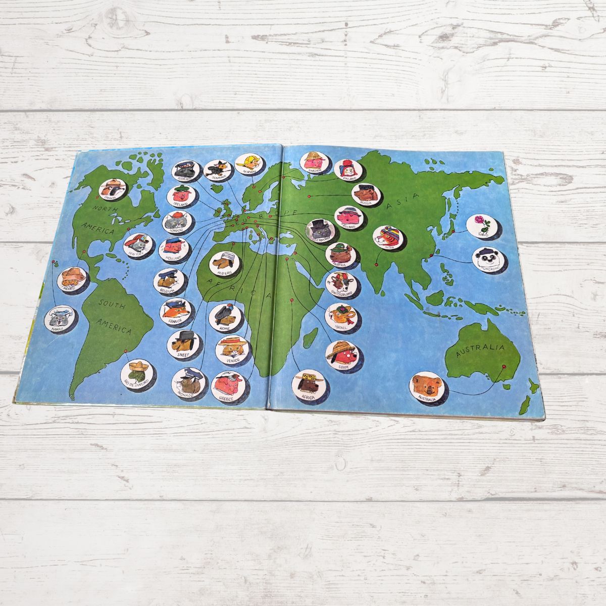 World map in book with various characters  on a wooden surface