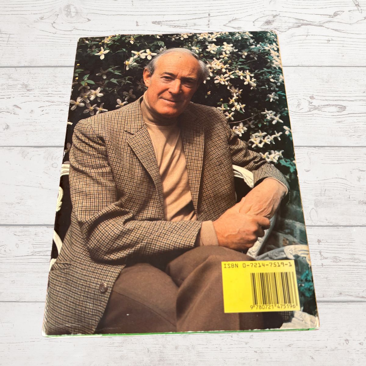 Vintage photo of a man in a suit with a floral background on a wooden surface