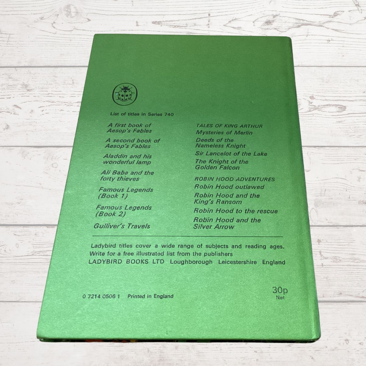 The back cover of a green Ladybird Books children's book, titled 'A List of Titles in Series 740', photographed flat on a white wood background.