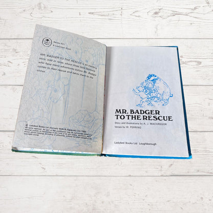 An open vintage hardcover book titled 'Mr. Badger to the Rescue' laid flat on a white wood surface, showing the illustrated front cover and the inner printed pages.