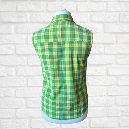 Green and yellow plaid vest on a mannequin against a white brick wall background